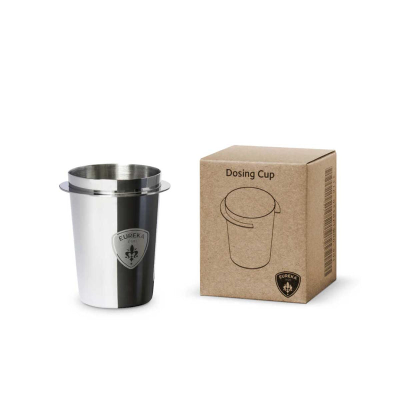 Stainless steel dosing cup with Eureka logo next to its cardboard box on a white background