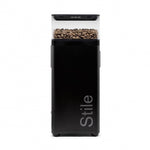 Black coffee grinder with 'Stile' branding and coffee beans on a white background